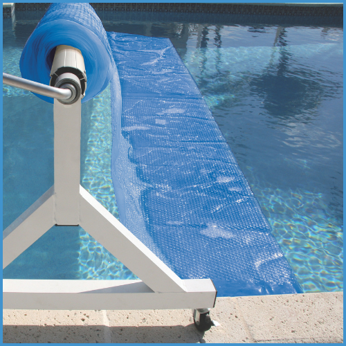 A solar pool cover on a reel, placed on top of a pool to retain heat and reduce water evaporation.